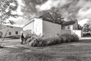 Milk house in back built against the existing spring house in 18